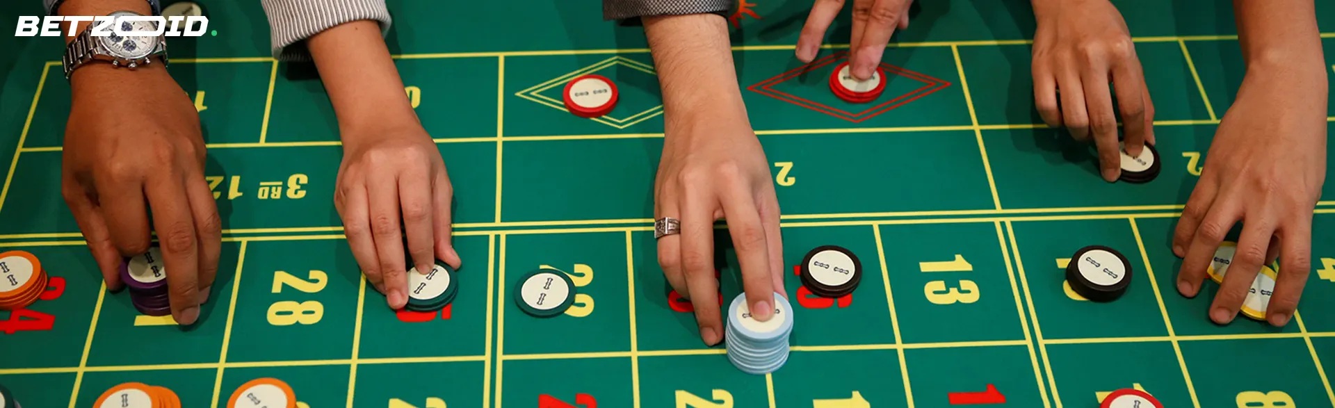 Players place bets with chips on the casino table.