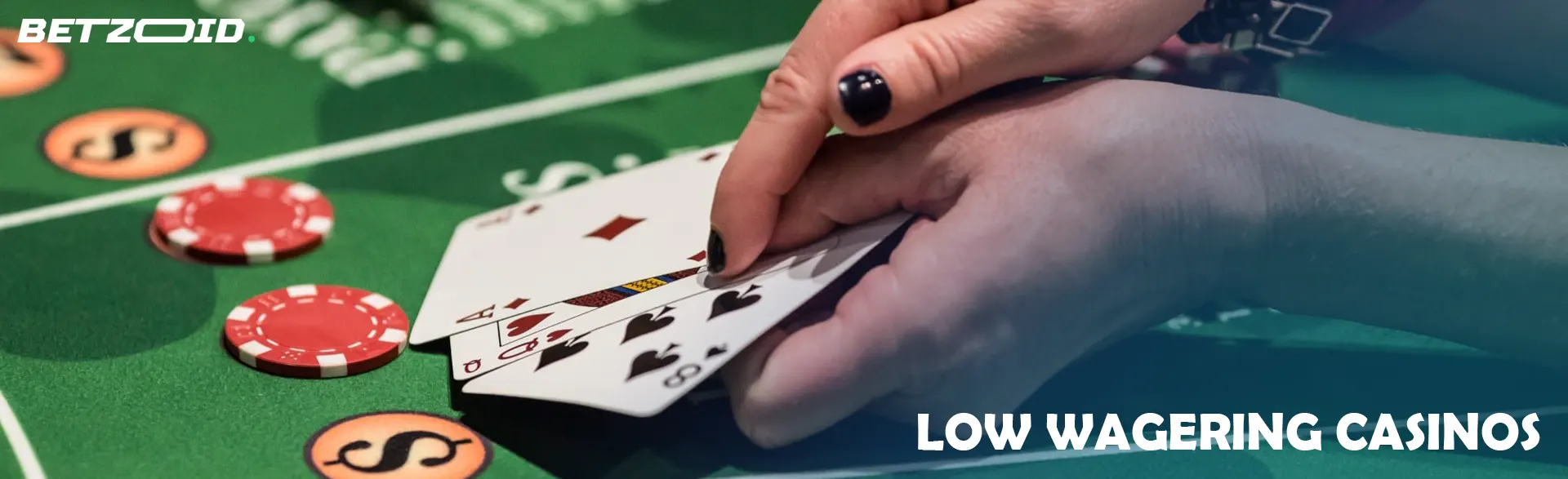 Player holding cards on casino table.