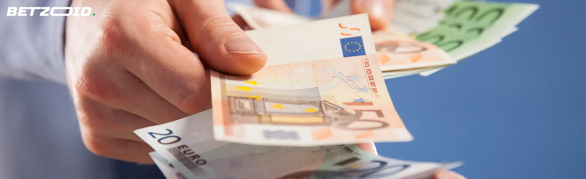 Mano sosteniendo billetes de euro en casas de apuestas con cashback.
