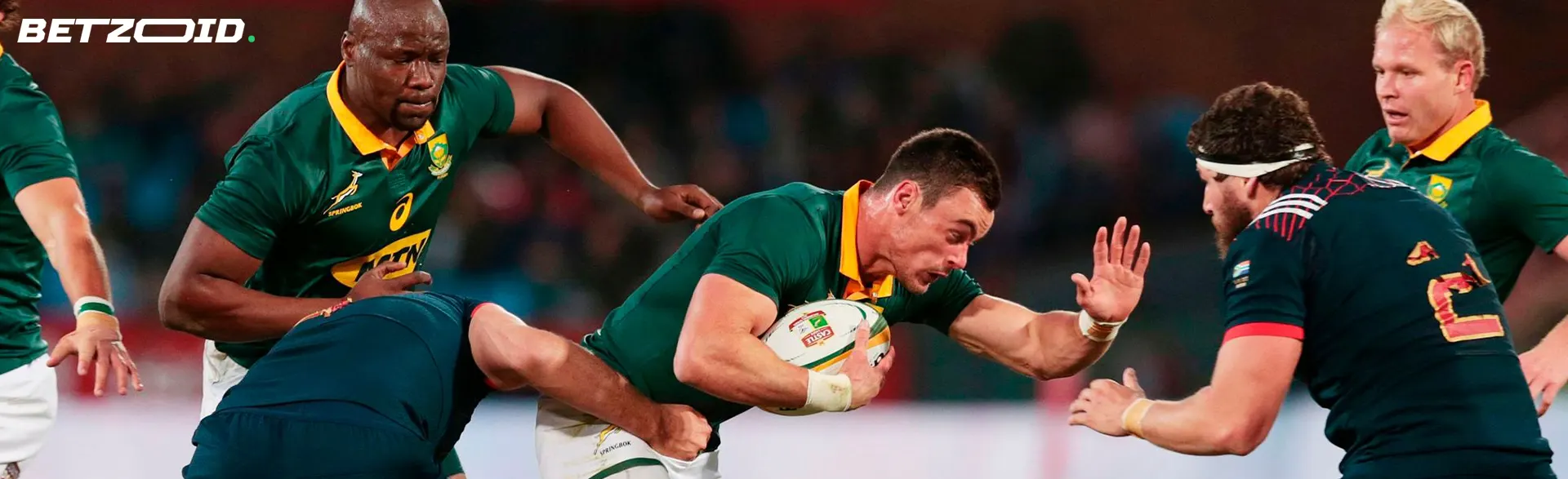 A rugby player breaks through the defense while holding the ball.