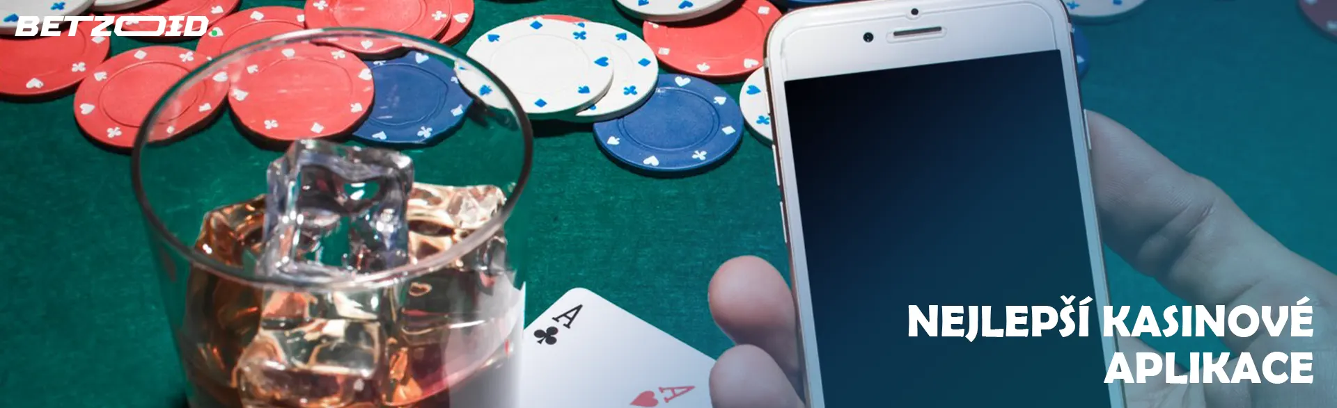 Hráč drží smartphone vedle nápoje ve sklenici a kasinových žetonů.
