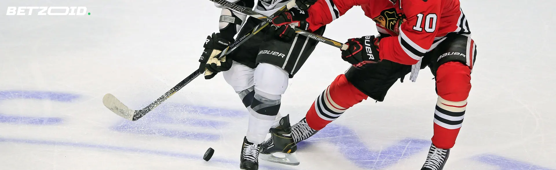 Hockeyspieler mit Schlägern kämpfen um den Puck.