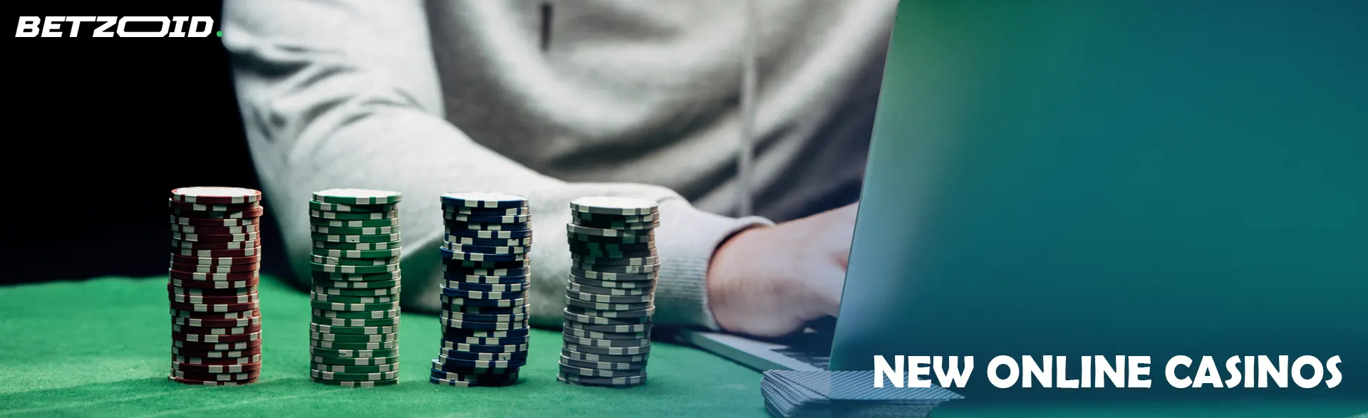 The player is sitting at the laptop with chips on the table.