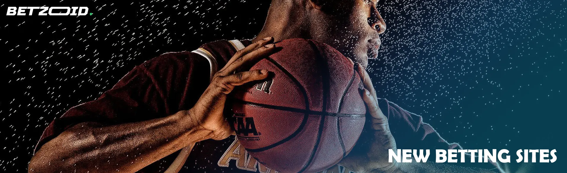 A basketball player holds the ball in the rain.