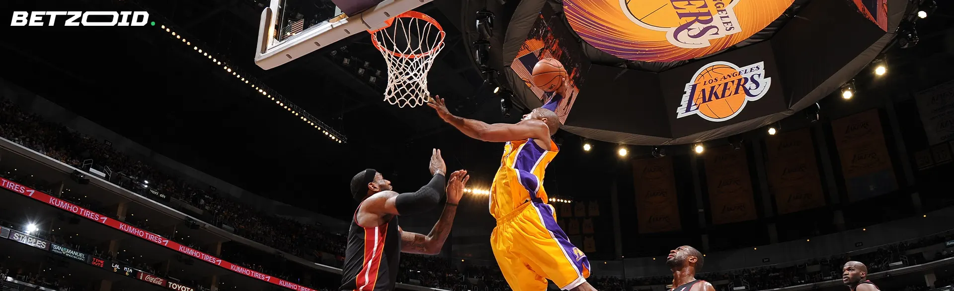 A basketball player jumps for a shot in the hoop during a game.