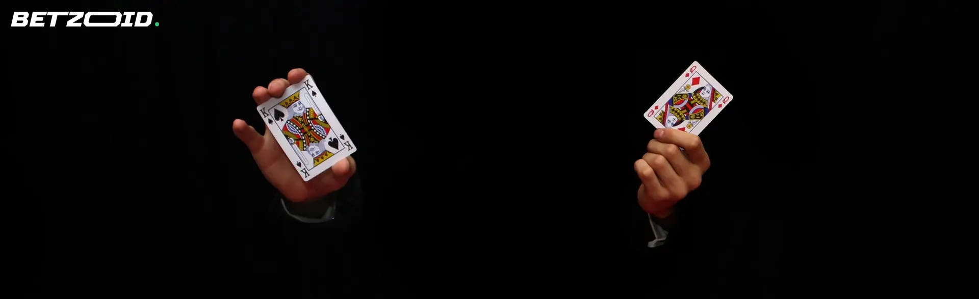 Two cards in the hands of a man - a king and a queen on a black background.