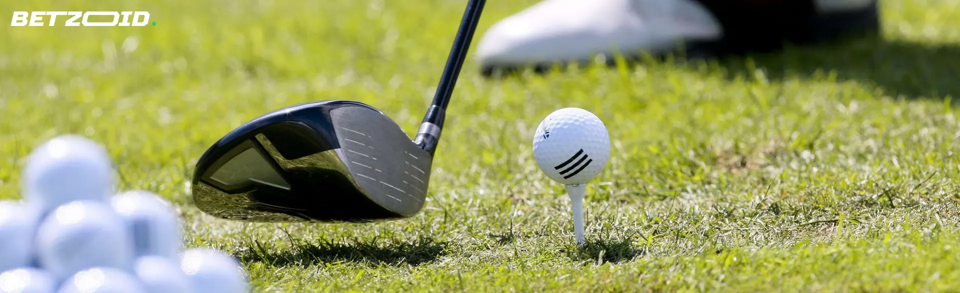 A golfer holds a club near a ball.