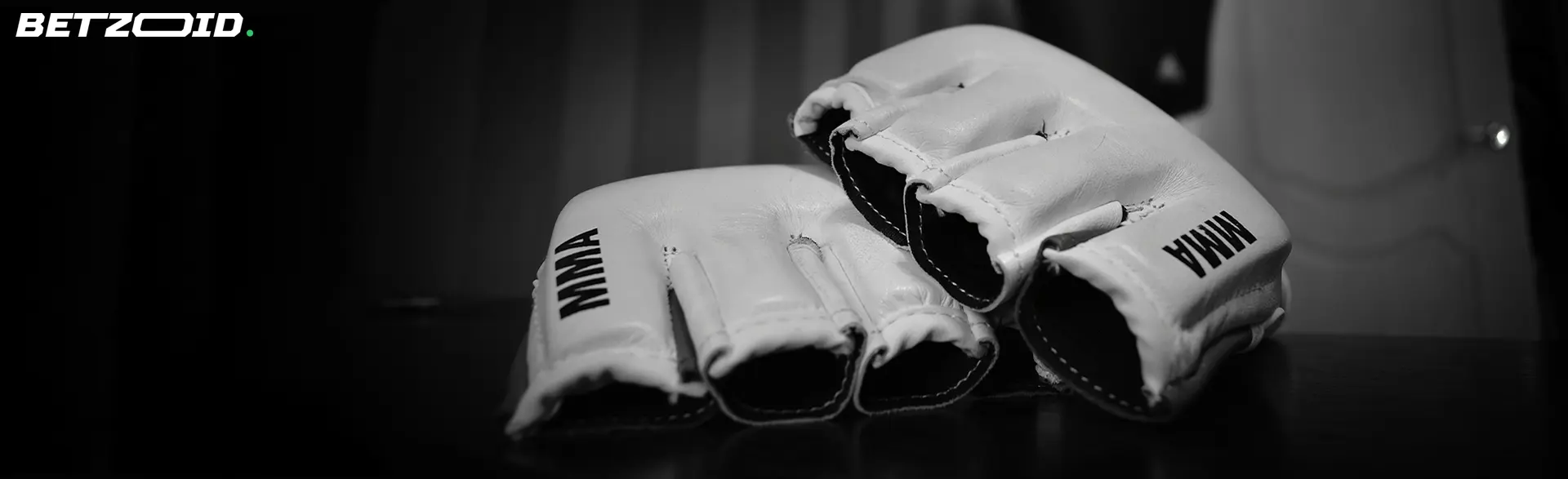 Worn white MMA gloves on a dark background, illustrating the intense and competitive nature of sports ideal for exploring no-risk matched betting Canada opportunities.