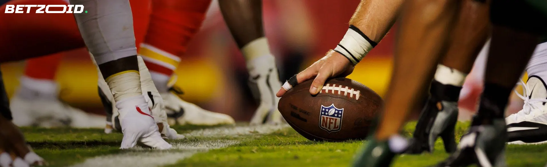 A close-up of football players' feet on the field, ready to start a play, representing NS sportsbooks.