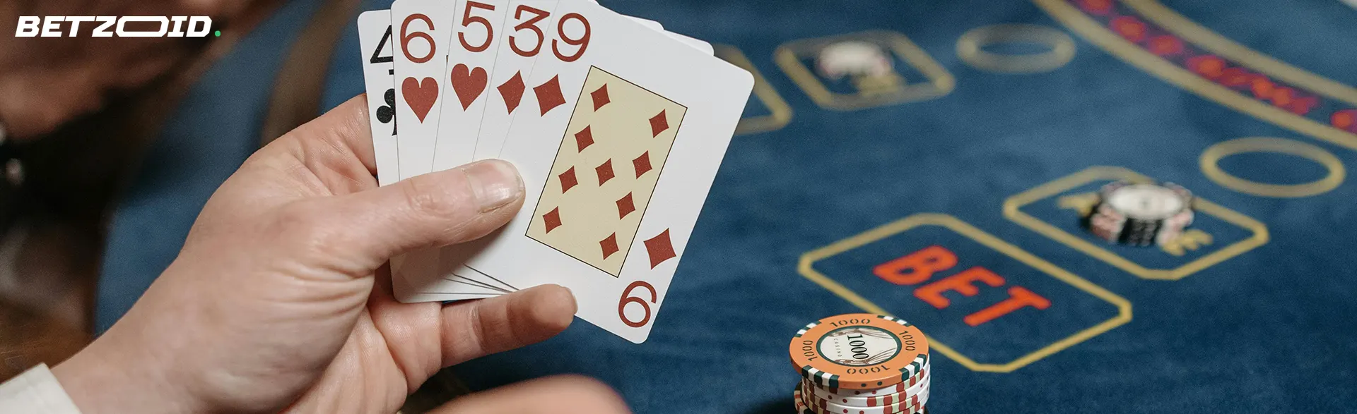 Cards in the player's hand on the background of the casino table.