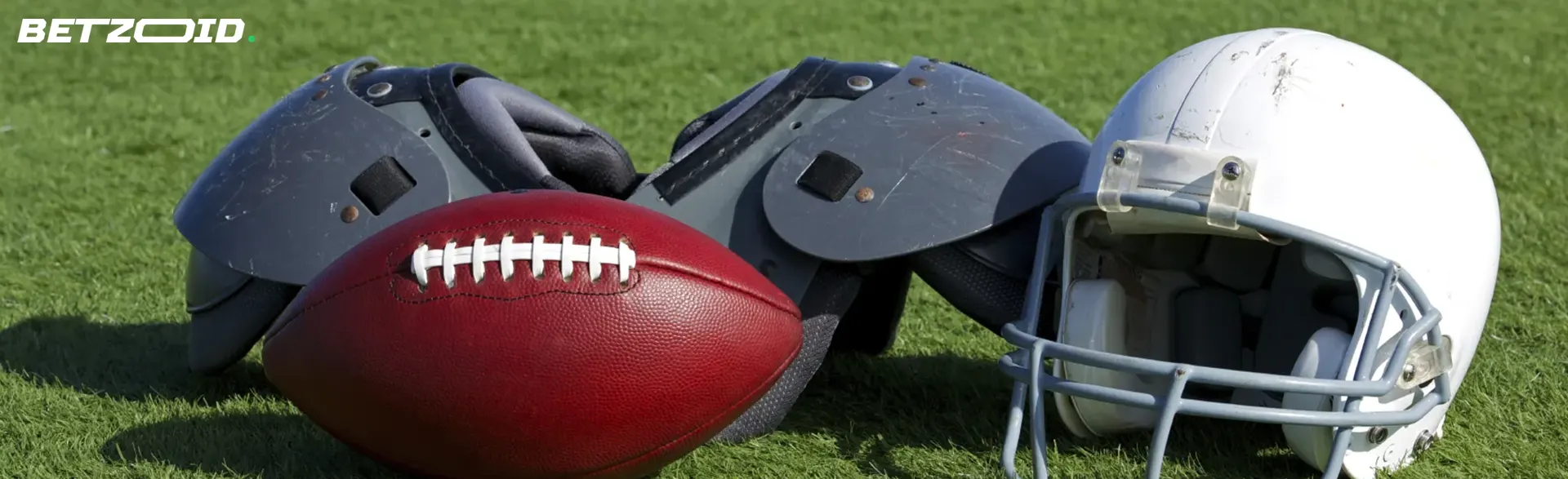 American football equipment lies on the grass.