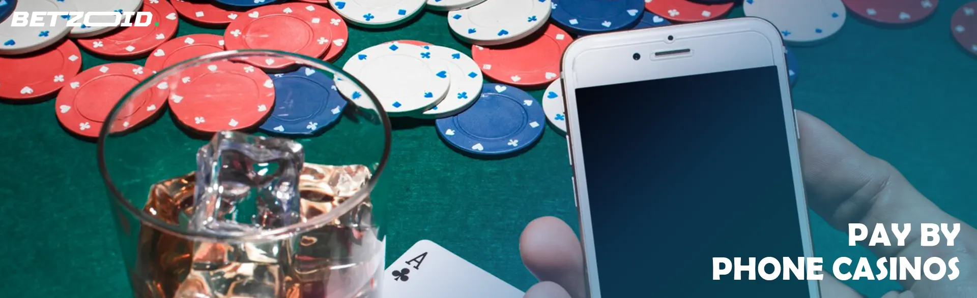 A player is holding a phone next to casino chips and a drink in a glass.
