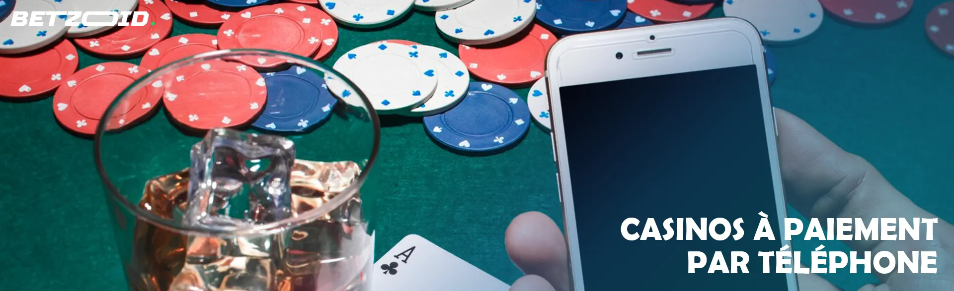 Un smartphone dans les mains du joueur, des jetons de casino et une boisson dans un verre. 