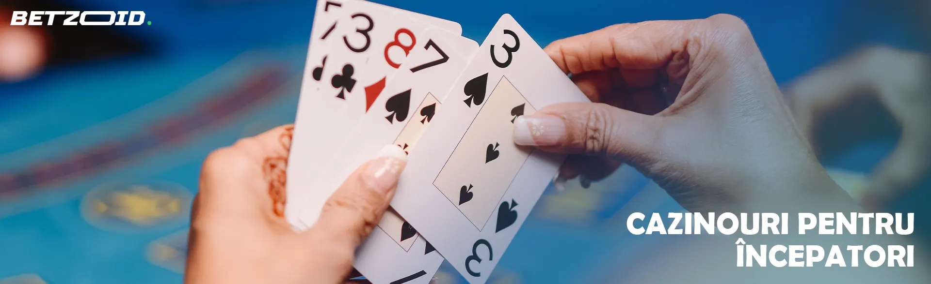 Cărți în mâinile jucătorului pe fundalul mesei de cazinou.