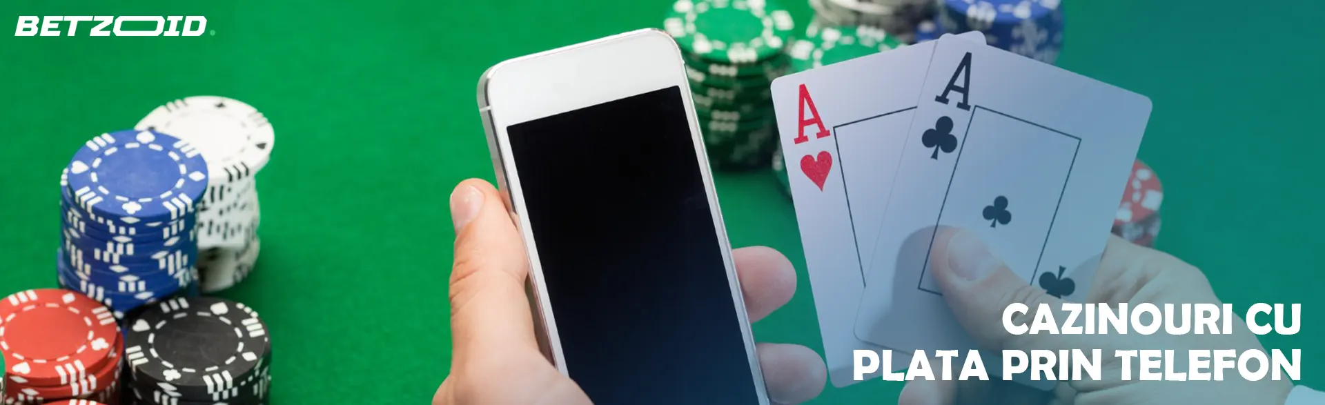 Jucătorul ține în mână un smartphone și cărți pe fundalul jetoanelor de cazinou.