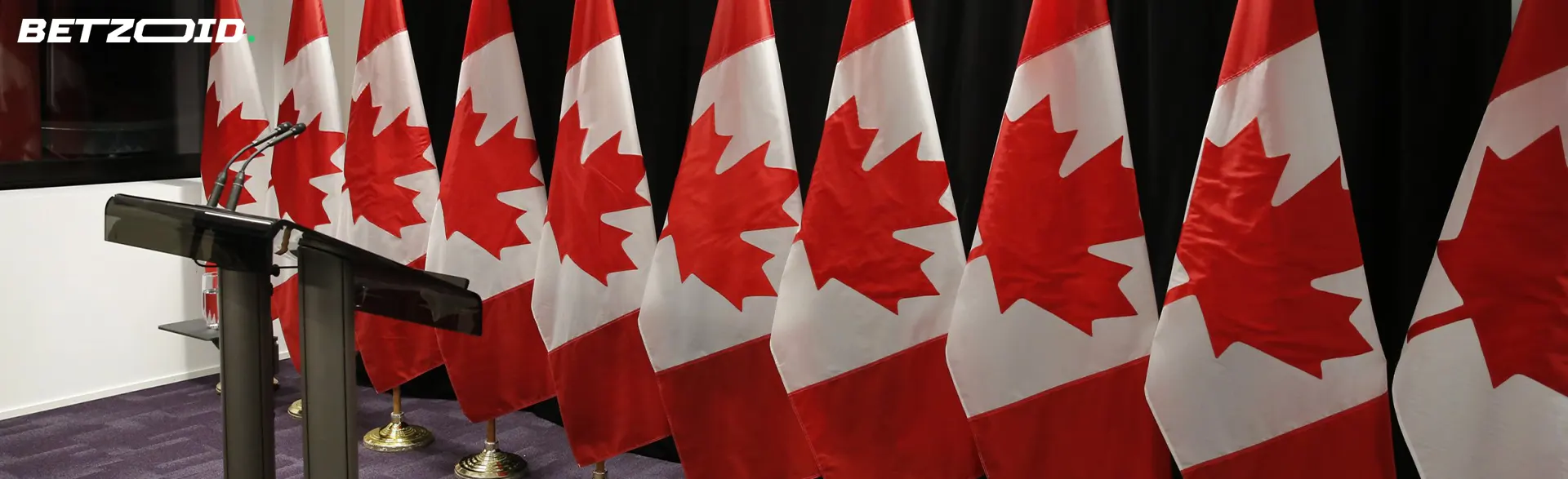 Press conference with Canadian flags in the background.