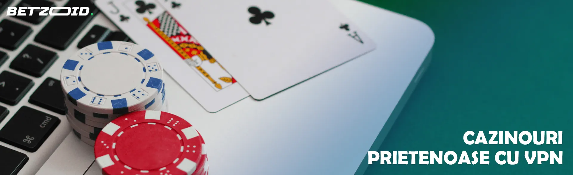 Cărți de cazinou și jetoane pe tastatura laptopului.