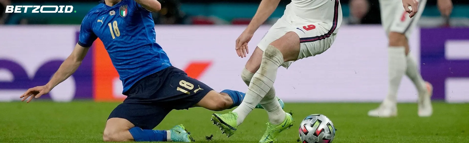 A football player makes a tackle, trying to catch the ball from an opponent.