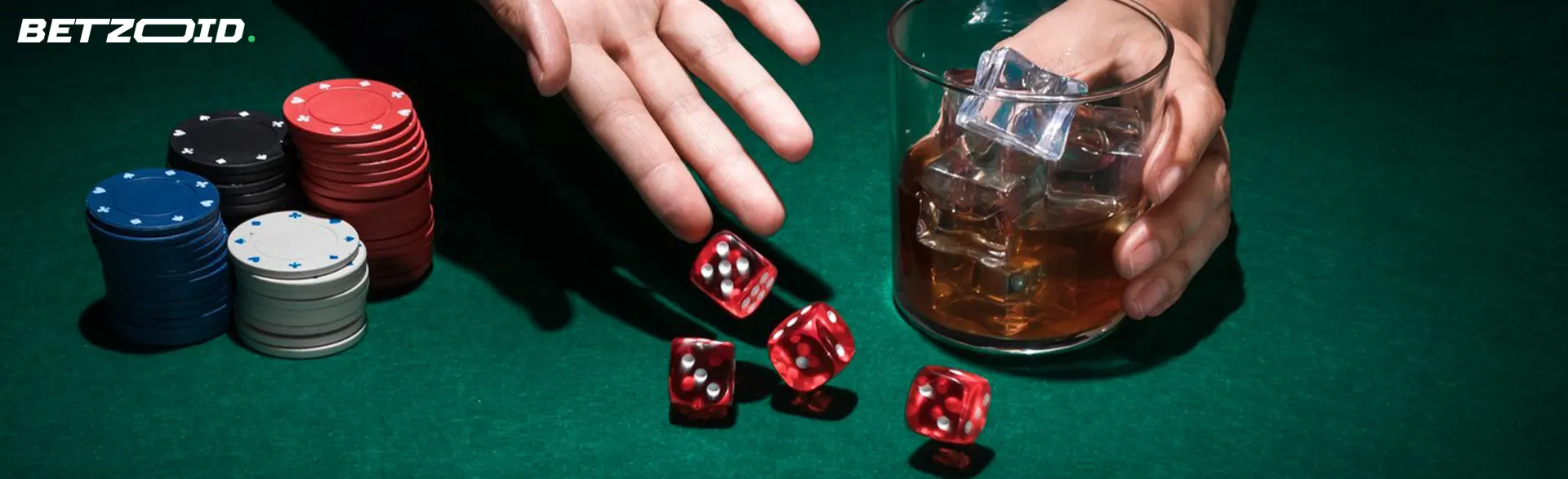 The player throws the dice on the casino table along with chips and a drink.