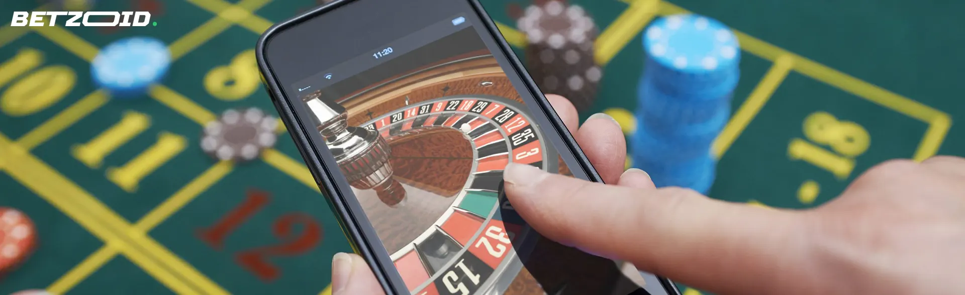 Jugador que sostiene un teléfono inteligente con ruleta en línea.
