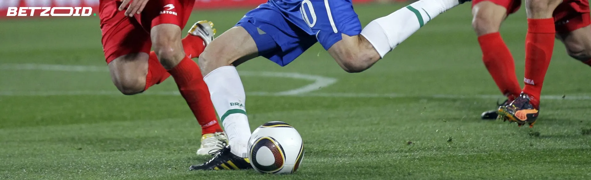 Two football players fight for the ball.