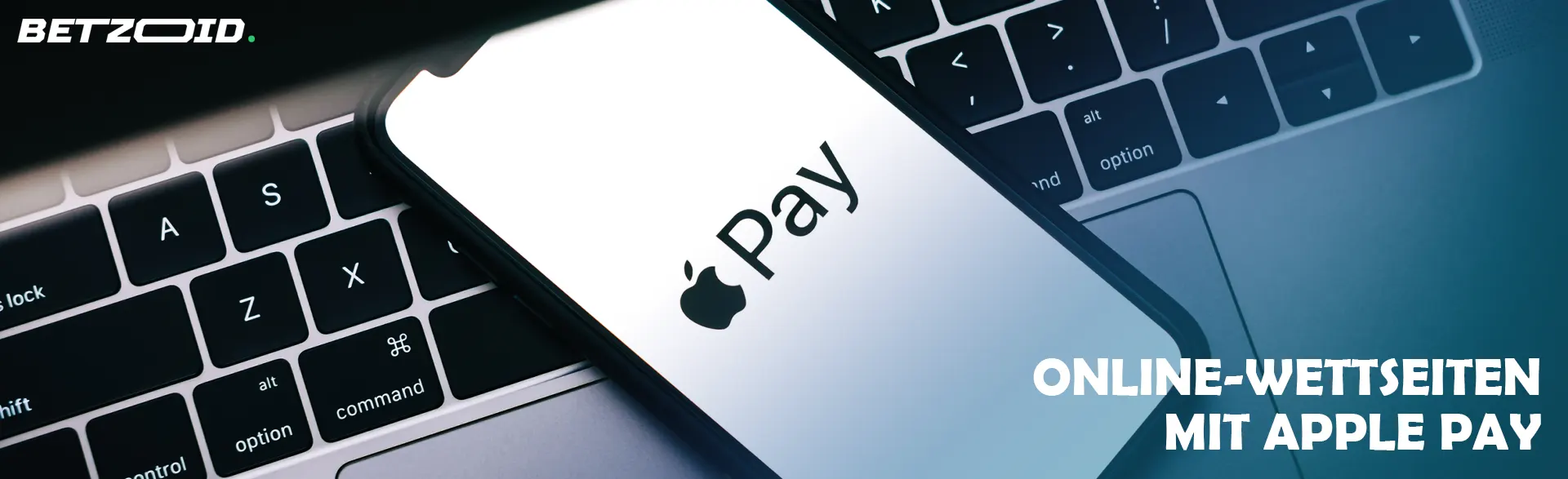 Auf einem Laptop liegt ein Smartphone mit dem Apple Pay-Logo.