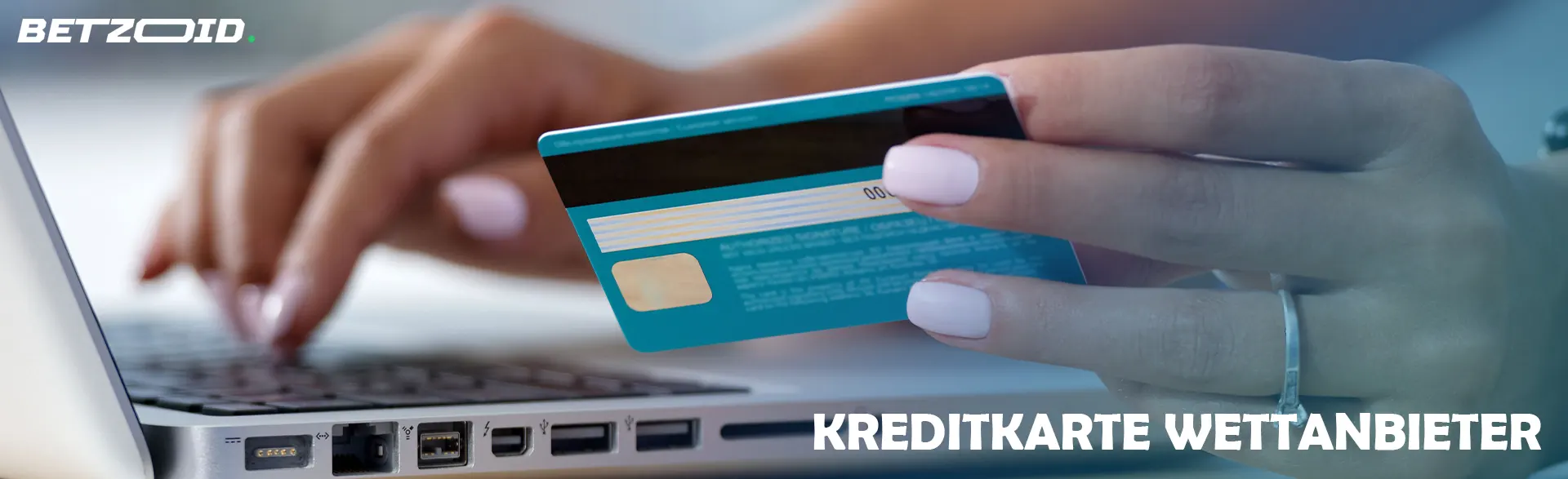 Mann hält Bankkarte vor Laptop.