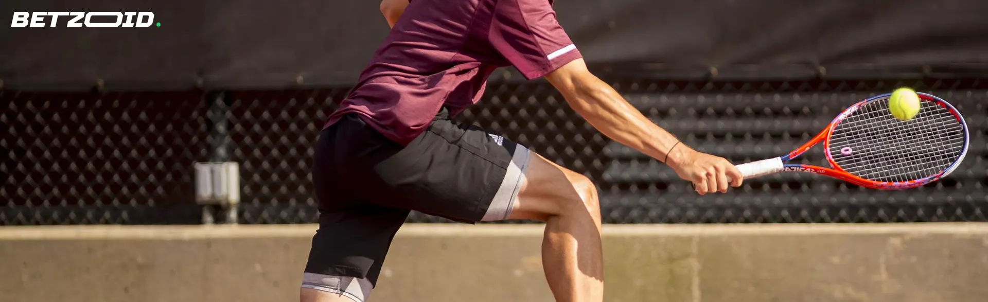 Ein Tennisspieler schlägt einen Tennisball.