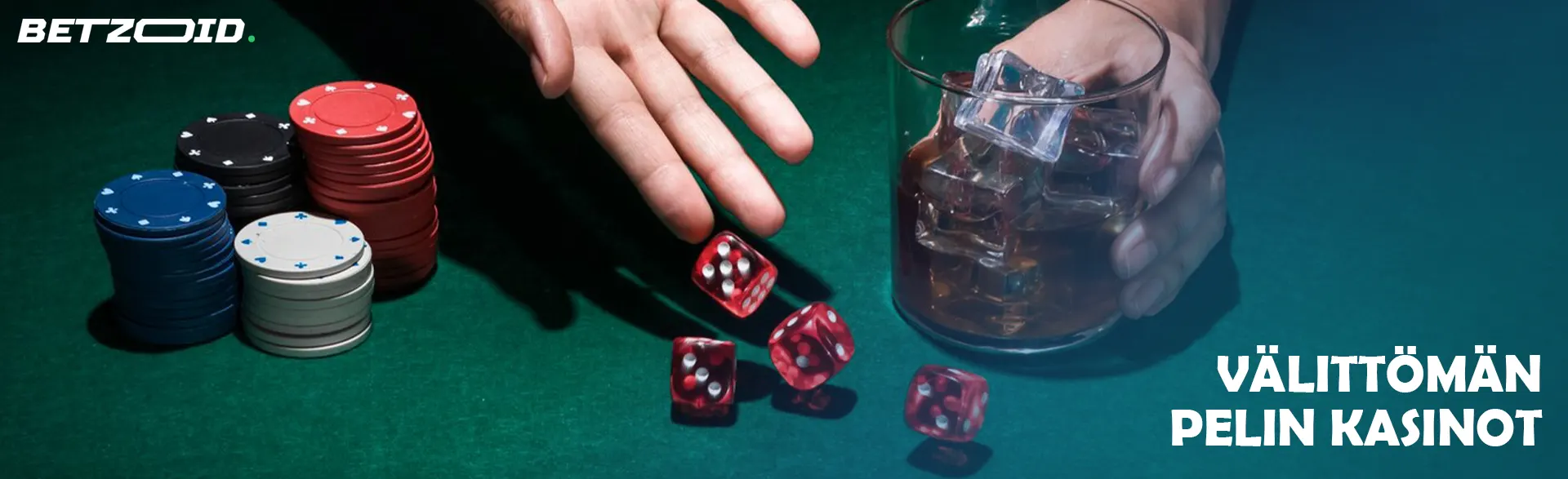 Pelaaja heittää noppaa kasinon pelimerkkien ja juoman viereen lasissa.