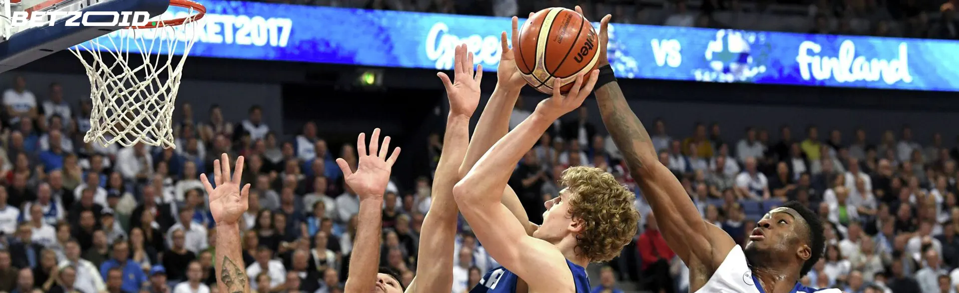 Koripalloilijat yrittävät heittää pallon vanteeseen.