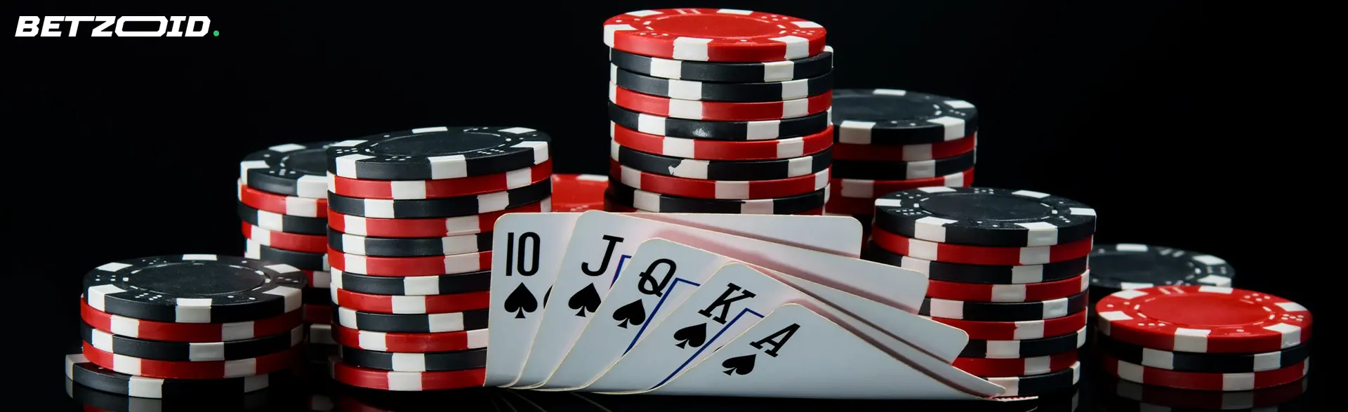 Cards and a pile of casino chips on a dark background.