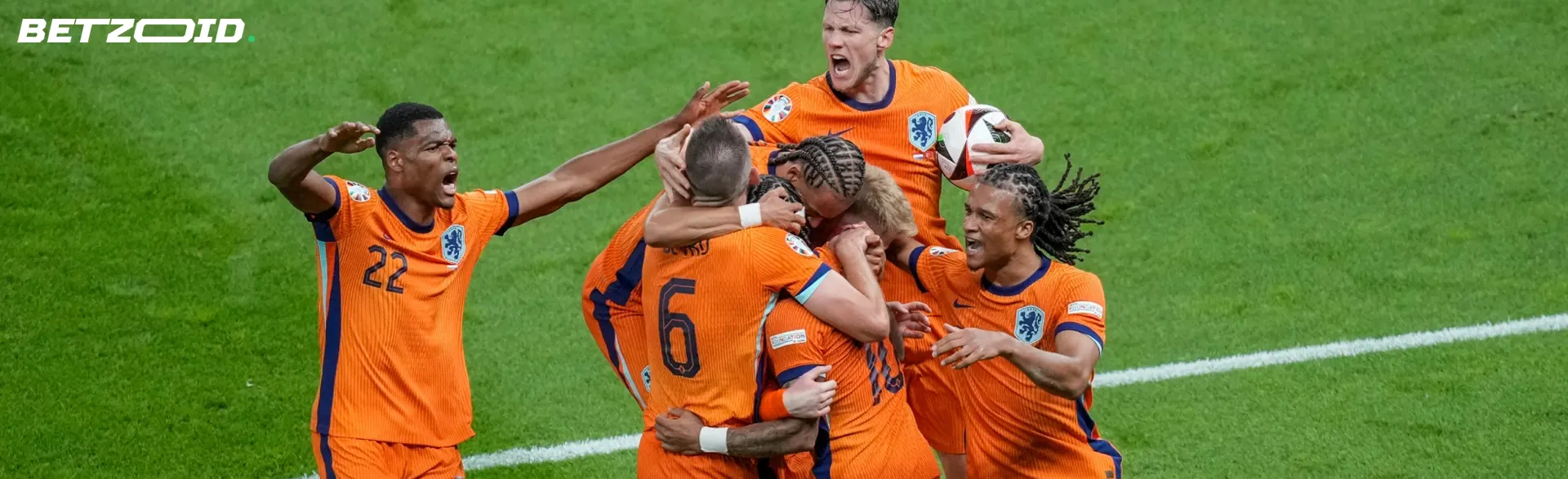 Een team voetballers juicht op het veld.