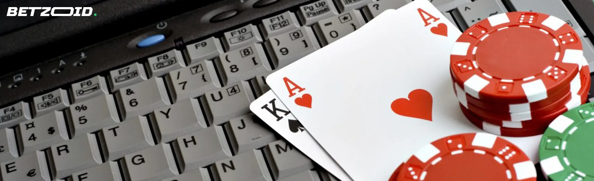 Casino cards and chips lie on the keyboard.