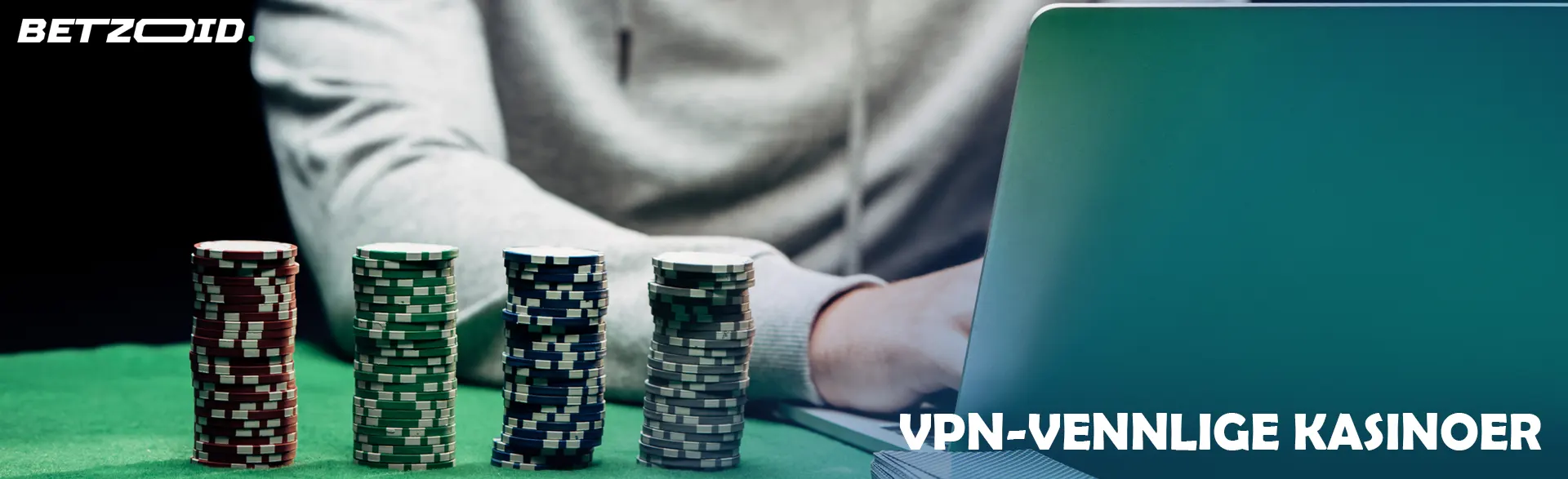 En gambler ved en bærbar PC ved siden av stabler med kasinosjetonger.