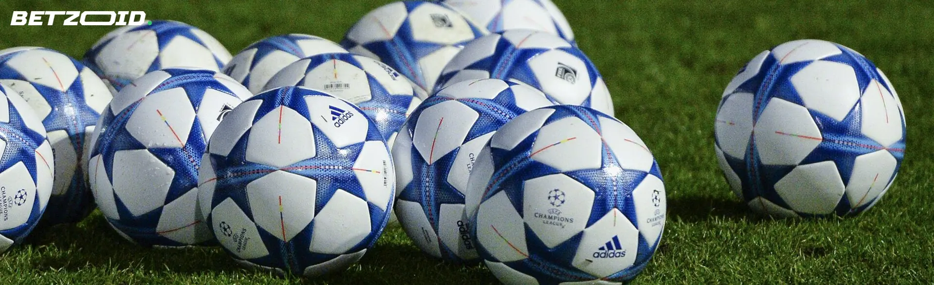 A pile of soccer balls on the field.